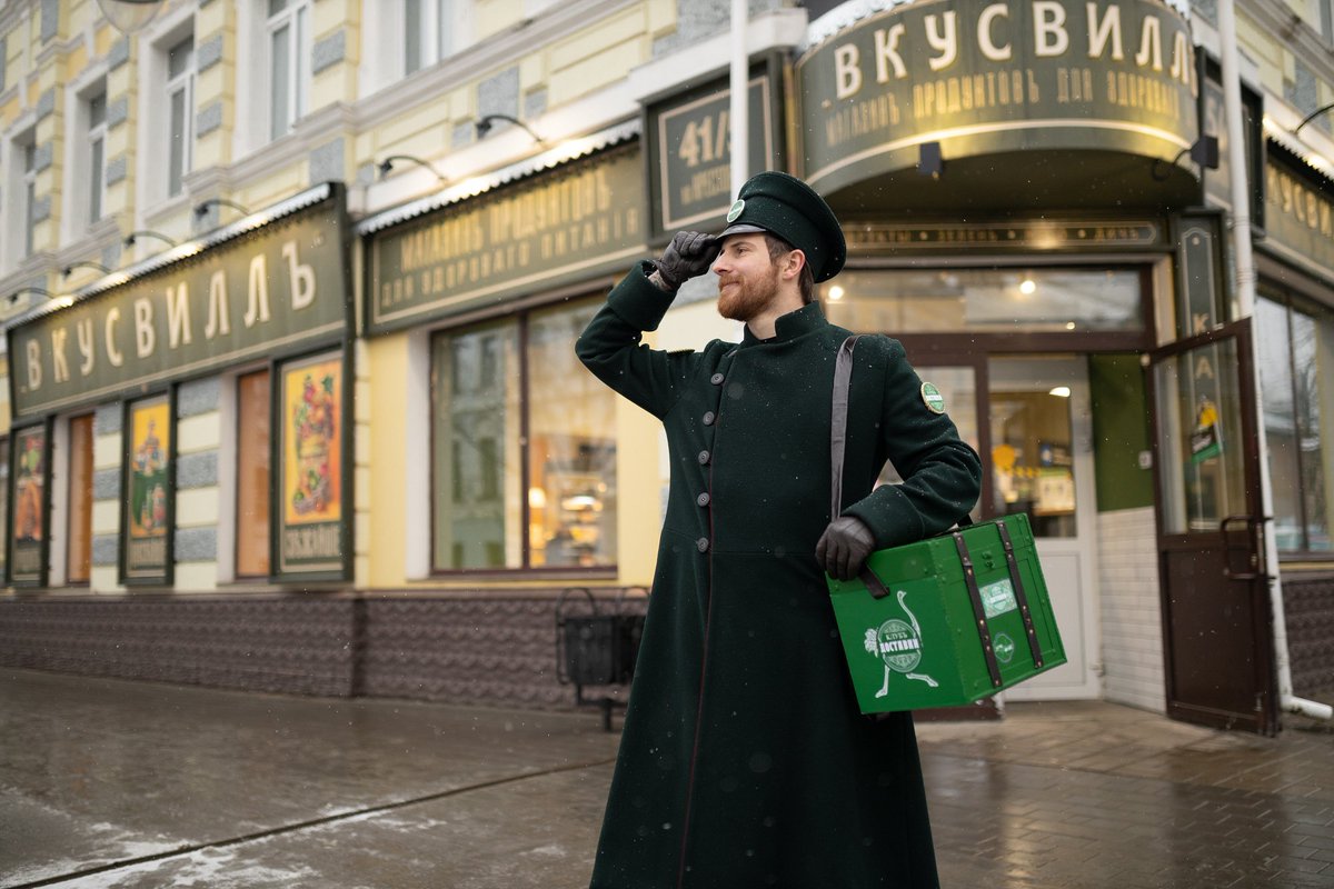 tjournal's tweet photo. В Рыбинске, где все вывески в центре должны делать в дореволюционном стиле, Delivery Club переодел курьера в ретро-форму. 

Сотруднику выдали шинель, фуражку и перчатки, а зелёный рюкзак заменили на короб с кожаными ремешками и логотипом в старинном стиле

https://t.co/jVyuPFY64e https://t.co/E6NTGOkOhS