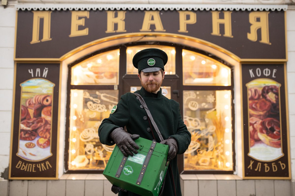 tjournal's tweet photo. В Рыбинске, где все вывески в центре должны делать в дореволюционном стиле, Delivery Club переодел курьера в ретро-форму. 

Сотруднику выдали шинель, фуражку и перчатки, а зелёный рюкзак заменили на короб с кожаными ремешками и логотипом в старинном стиле

https://t.co/jVyuPFY64e https://t.co/E6NTGOkOhS