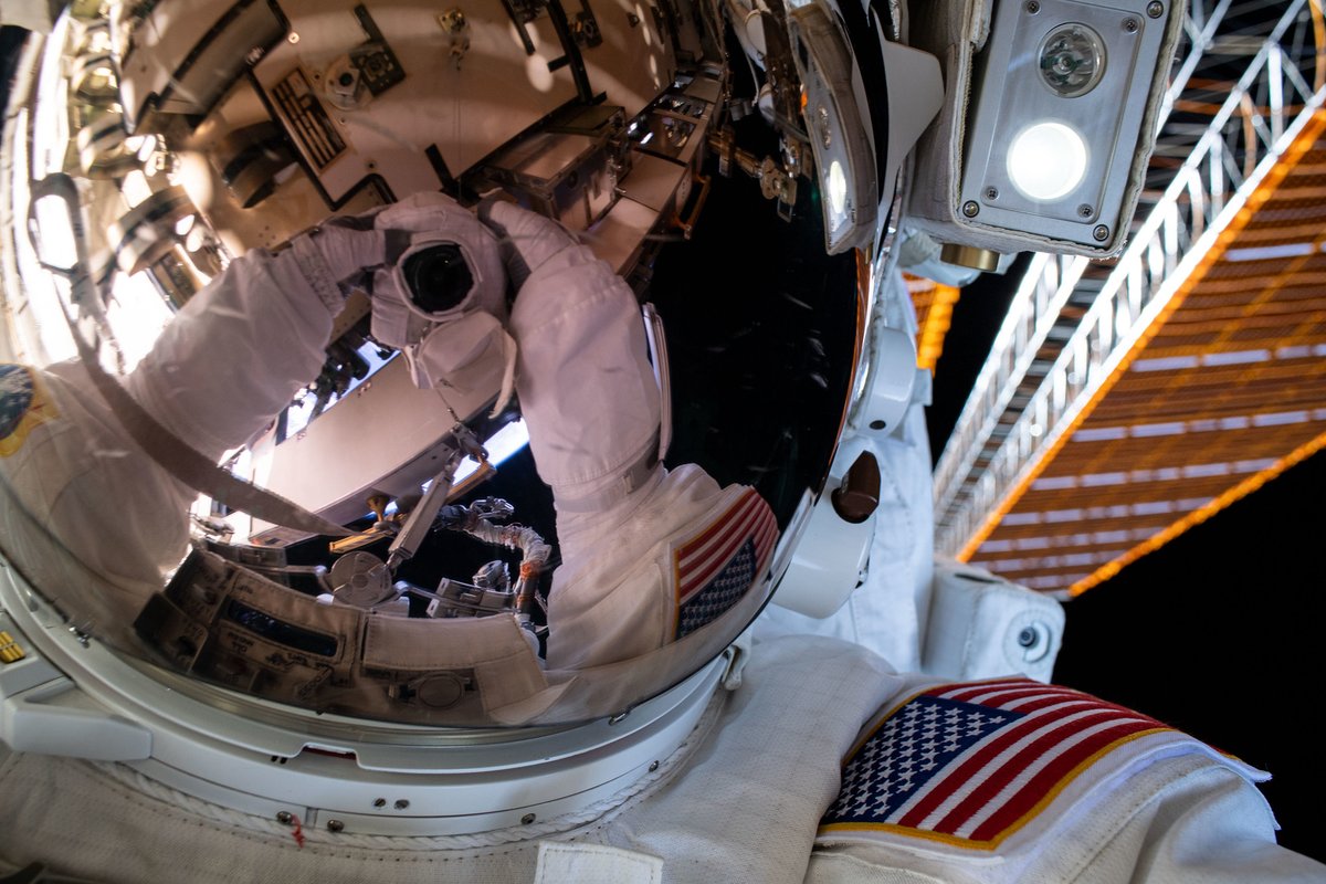 Astronaut selfie durin a spacewalk. Da camera is reflected up in tha visor.