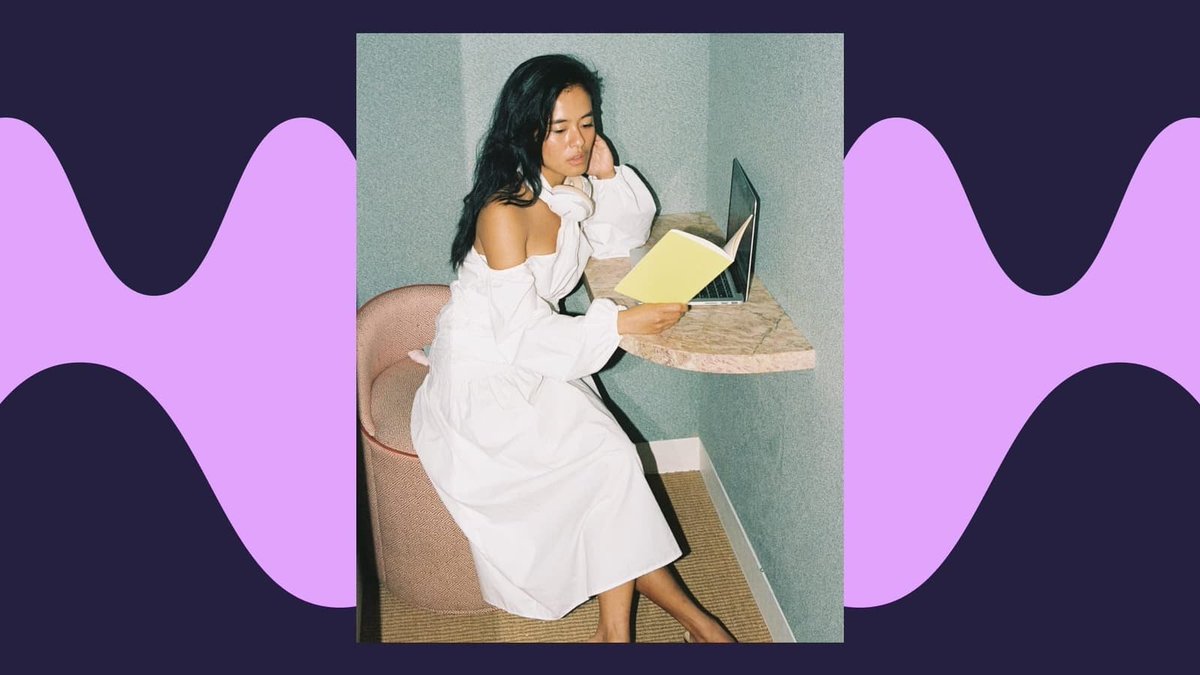 Olivia sits in the corner in front of a laptop, with her headphones around her neck, reviewing her journal.  Background is a sound wave design.