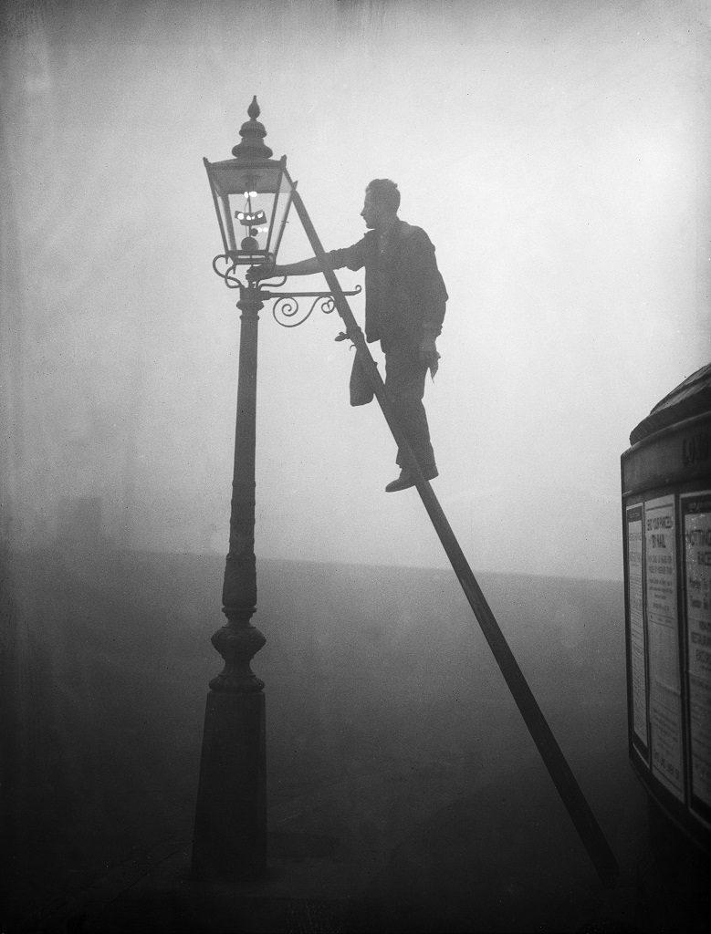 A lamp lighter at work in Finsbury Park, London October 1935 E. Dean