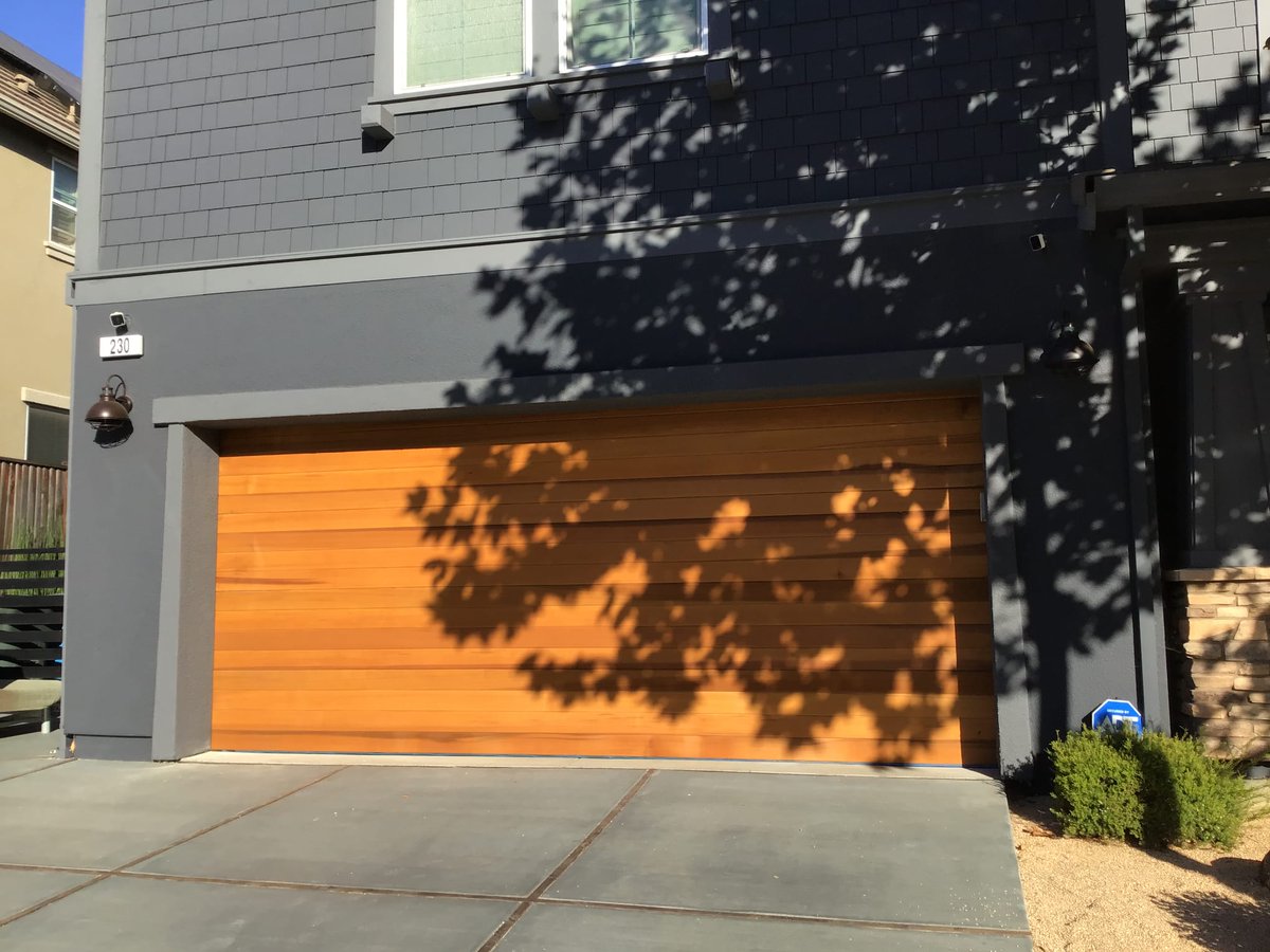 Achieve a high-end look with this Modern Wood Garage Door that incorporates horizontal v-groove smooth cedar wood planks. 

#homeimprovement #garagedoors