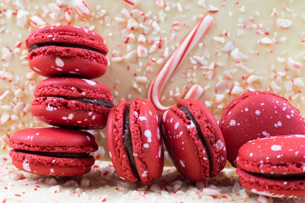 Where's the candy cane emoji when you need it?!🎁🎄This macaron comes with a chunk of white chocolate peppermint bark made with delicious crushed candy canes in the center giving it the perfect melty crunch. 
#candycanes #peppermintbark #holidayclassics
