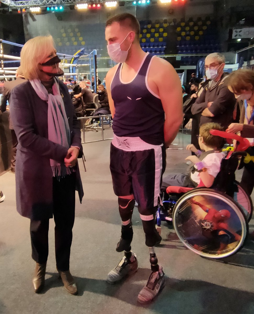 Sophie Cluzel discute avec un boxeur amputé qui marche avec des prothèses de sport.