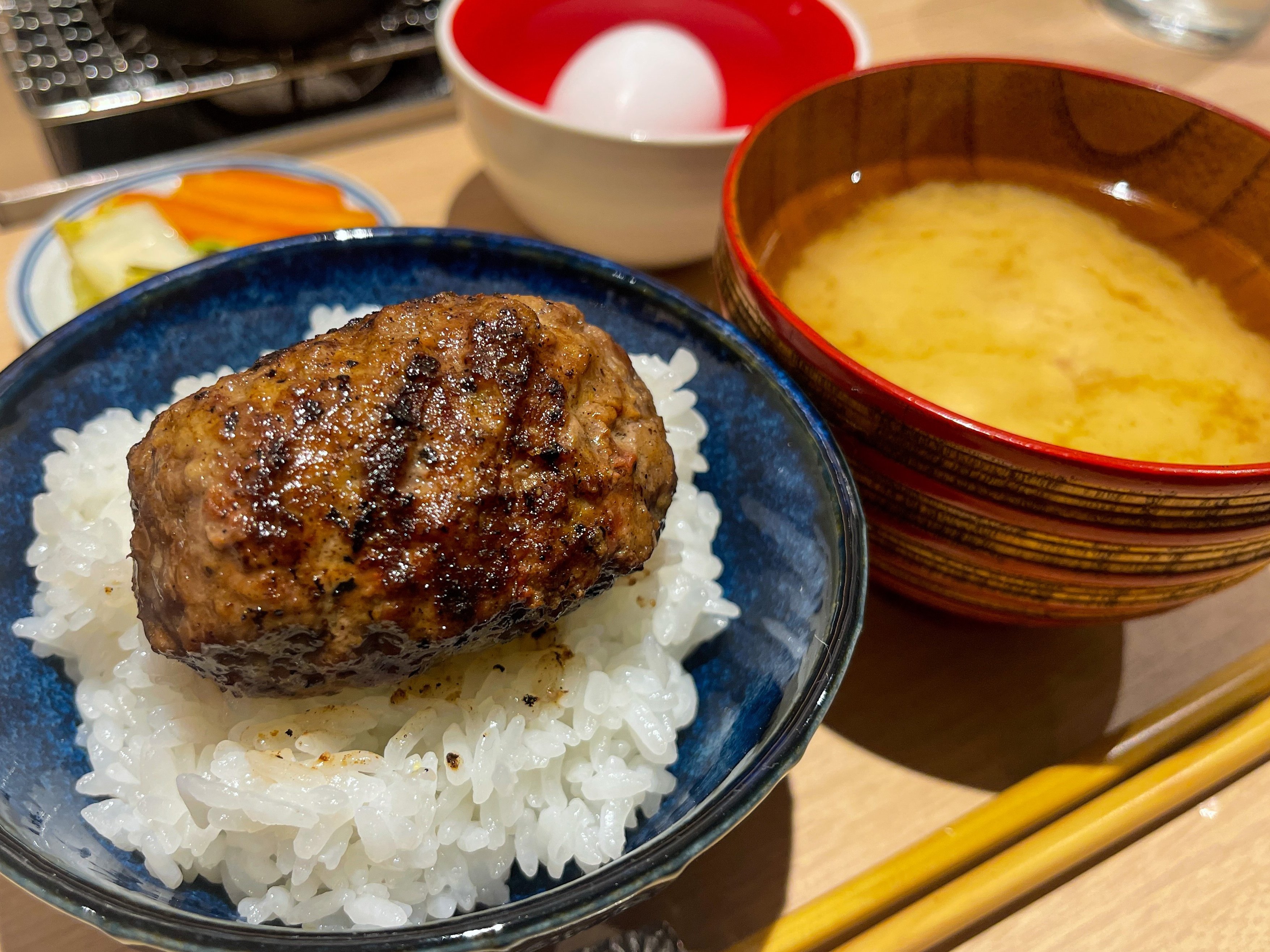 唯一無二の絶品グルメ むにぐるめ ハンバーグ嘉 原宿駅から徒歩9分 炭火焼きハンバーグと羽釜で炊いたご飯を食べられるお店 店内中央で豪快に焼き上げるハンバーグは旨味を閉じ込めたジューシーな仕上がり デミグラスやチーズと絡めたり 卵と