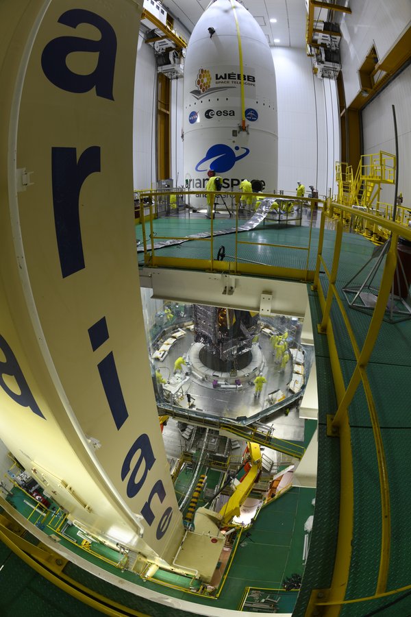 A protective nosecone containing the James Webb Space Telescope is emblazoned with logos for NASA, the European Space Agency, Canadian Space Agency and Arianespace.