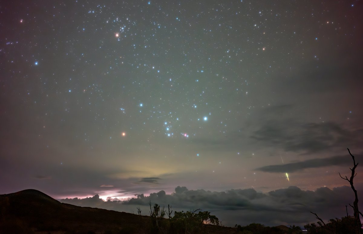 The clouds opened up briefly from the Mauna Kea access road as distant storms boiled over Hilo. For a short while, Orion was visible as it rose over the scene. In this shot, right before the clouds took over, a storm tower lit up with lightning as a fireball grazed the horizon.
