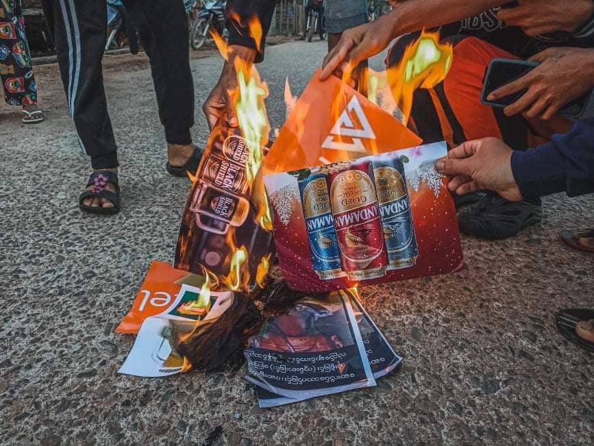 MhuKyot's tweet photo. Students Union &amp; youths of Launglone Tsp marched on the streets to protest against Genocidal Dictatorship &amp; demonstrated rejection of military by burning military owned product posters.
#EndImpunity
#Dec8Coup 
#WhatsHappeningInMyanmar https://t.co/Cl2SxZPLjj