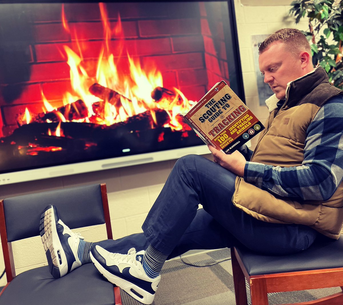 HiRMS_library's tweet photo. Somebody’s EXTRA into the spirit of Mad About Plaid day! Dr. T went full lumberjack and spent a few moments reading our tracking guide by the fire. 😆
#ridgereads📚

@hickoryridgemid @TimTaylorHiRMS https://t.co/C5D4ZWnkqo