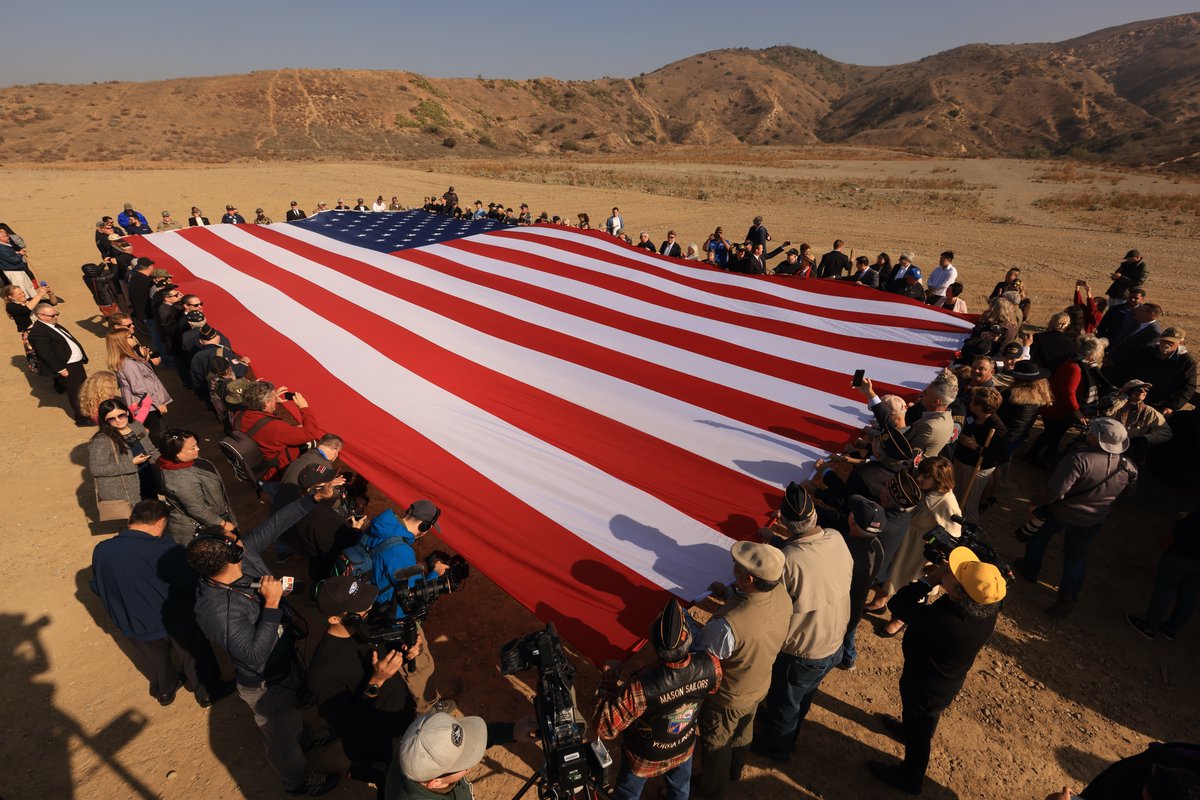DonWagnerCA's tweet photo. After a decade-long battle, we have bipartisan support for OC's first #VeteransCemetery. Honored to break ground with my colleagues at the Board, all 34 city reps, and Veteran community. We unfurled a 60'x30' American flag that will wave from the hilltop. #FlagOne #AnaheimHills https://t.co/oSZnnDUWnu