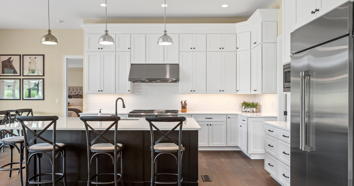 The timeless stainless steel finish on the appliances and lighting complement this dark flooring &amp; island cabinetry, creating a contrast to the diffused under-cabinet lighting. What’s your favorite design trend that goes with stainless appliances?

Photo Credit: Greg Grupenhof