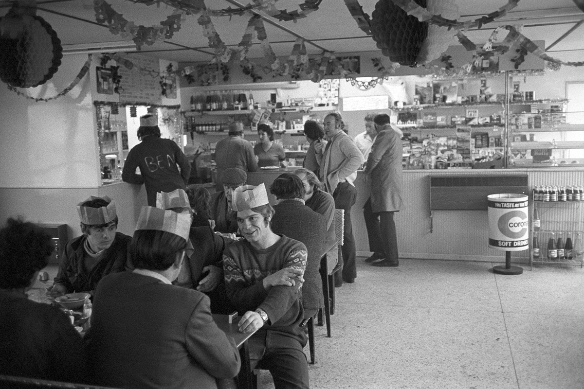 JamesRavilious's tweet photo. Free Christmas dinner in a transport café, Winkleigh, December 1974. Photograph by my Dad, digitally scanned from a Beaford Archive negative. ©Beaford Arts @beaford #Devon #photography #christmas #partyhats #transportcafe https://t.co/pazYA8VIZE https://t.co/9LiBwbI4W0