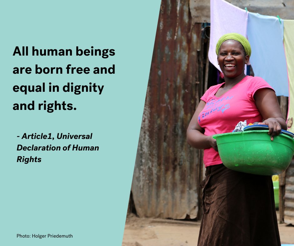Smiling woman doing laundry. Next to the picture text says: "All human beings are born free and equal in dignity and rights. - Article 1, Universal Declaration of Human Rights. Photo: Holger Priedemuth"