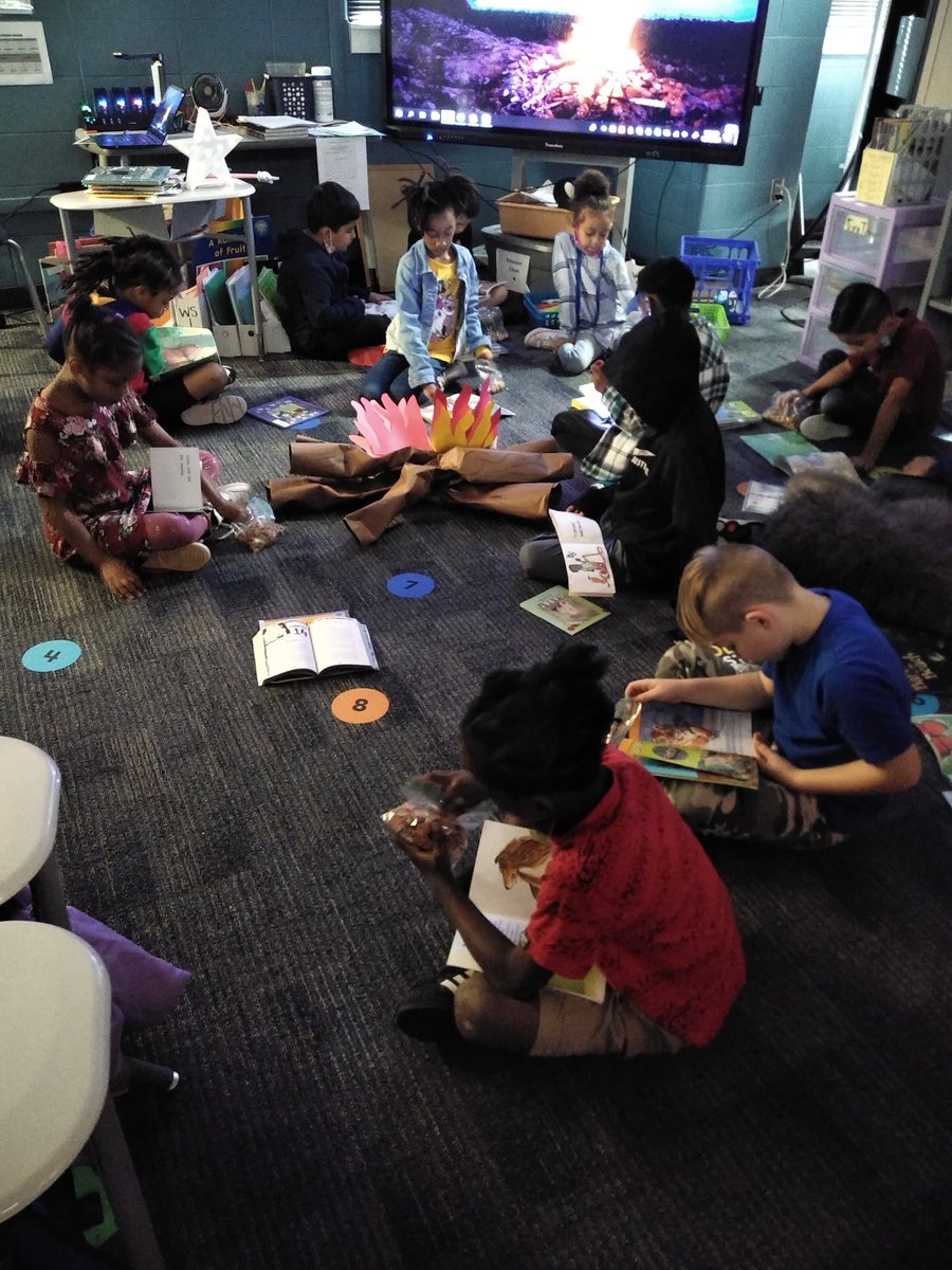 ManryMs's tweet photo. Reading fiction by flashlight at our campfire celebration. And eating s'mores cereal, too! https://t.co/fnclwtAvEb