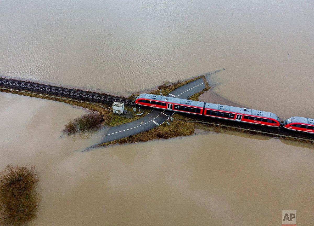AP's tweet photo. A train passes a railroad crossing that is surrounded by floodwaters from rain and melting snow in Nidderau near Frankfurt, Germany. The Rhine River flooded the only access road to the community.

By Michael Probst

MORE #APPhotos2021: https://t.co/7yALItMuhL

#YearinPictures https://t.co/EntbL9kmQI