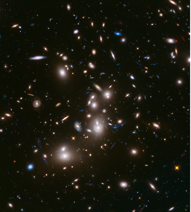 A Hubble deep field image.  Black background with scattered galaxies across it. 