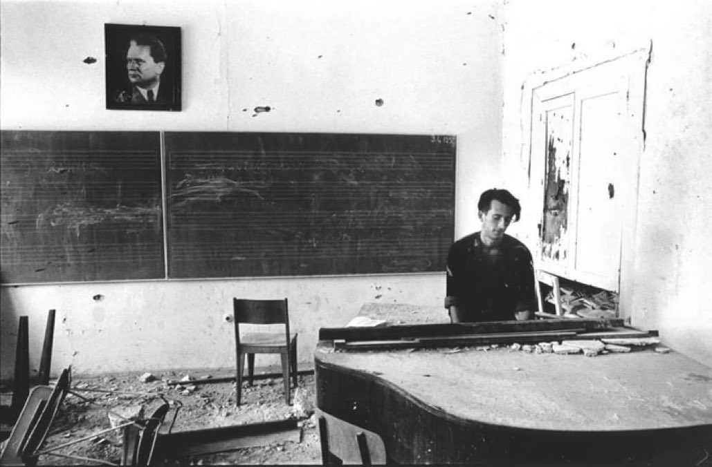 BosnianHistory's tweet photo. A #Bosnian soldier plays the piano in a destroyed music school, Mostar 1992.

📸 Teun Voeten https://t.co/tISXsfXT1V