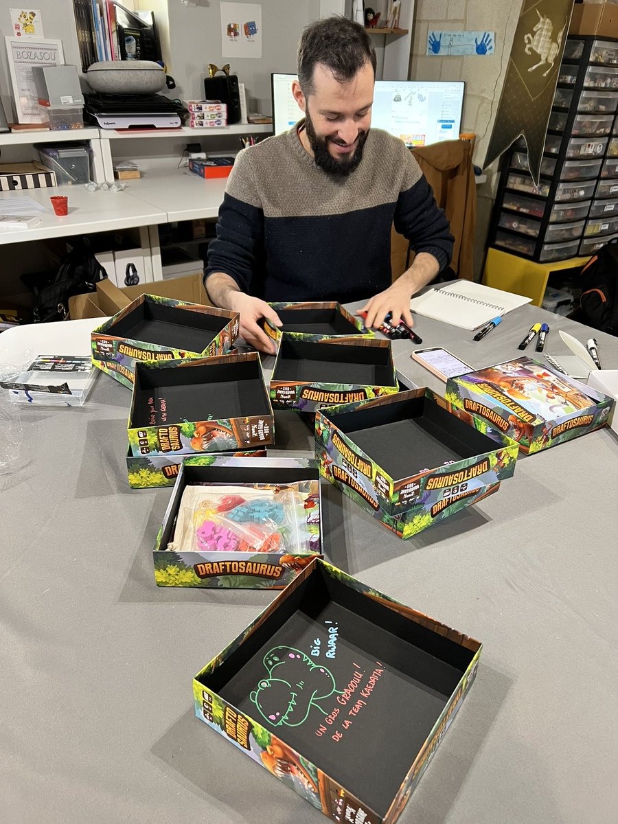 TeamKaedama's tweet photo. Voici @Akashinai qui dédicace un lot de #draftosaurus destinés au marché allemand ! #j2s #designeratwork #dinosaurs https://t.co/7tCvzfBpKJ