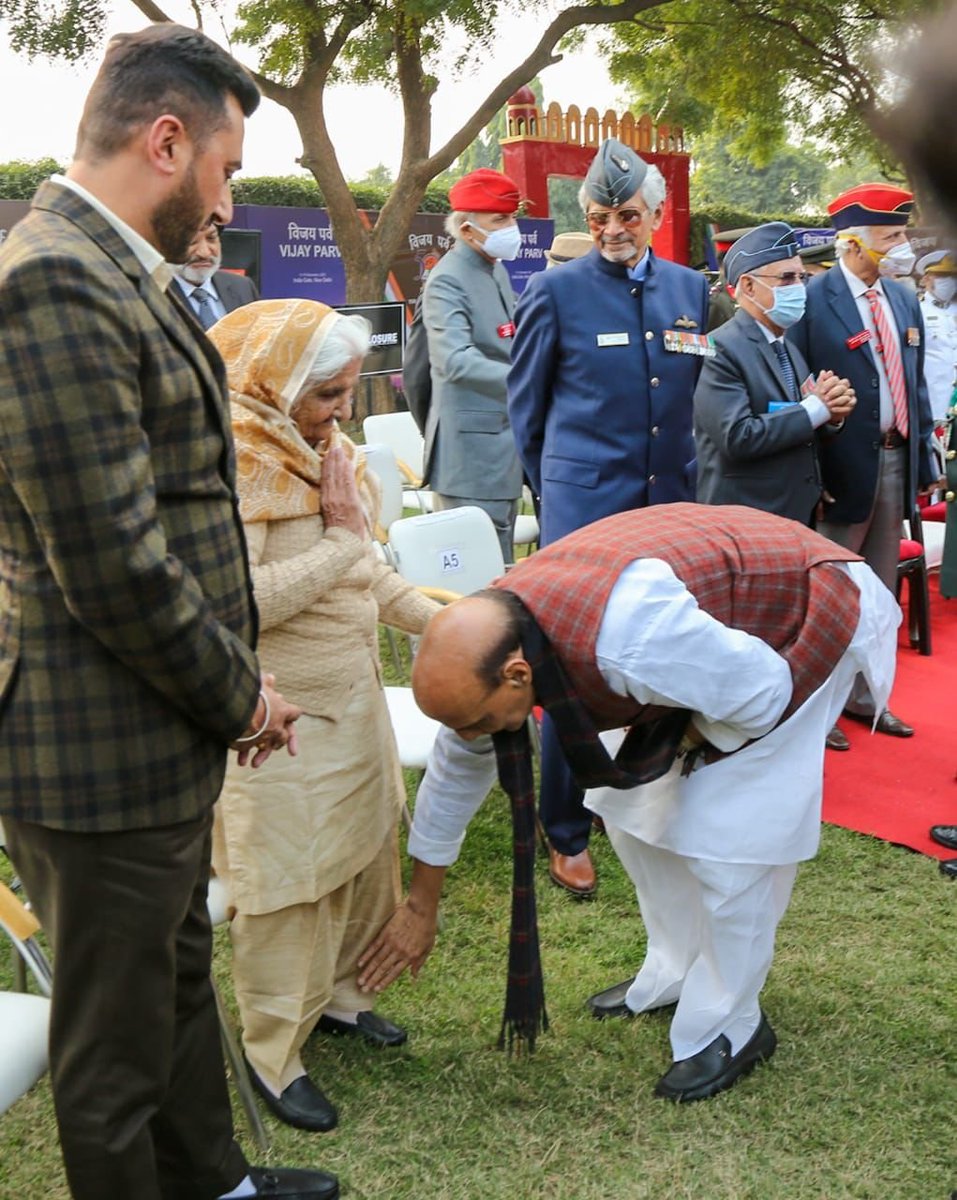 ANI's tweet photo. Defence Minister Rajnath Singh touched the feet of wife of Colonel Hoshiar Singh who was decorated with Param Vir Chakra for exhibiting exemplary courage in the 1971 war. The Defence Minister met her at Vijay Parv Samapan Samaroh in New Delhi today. https://t.co/tjm9oakyKm