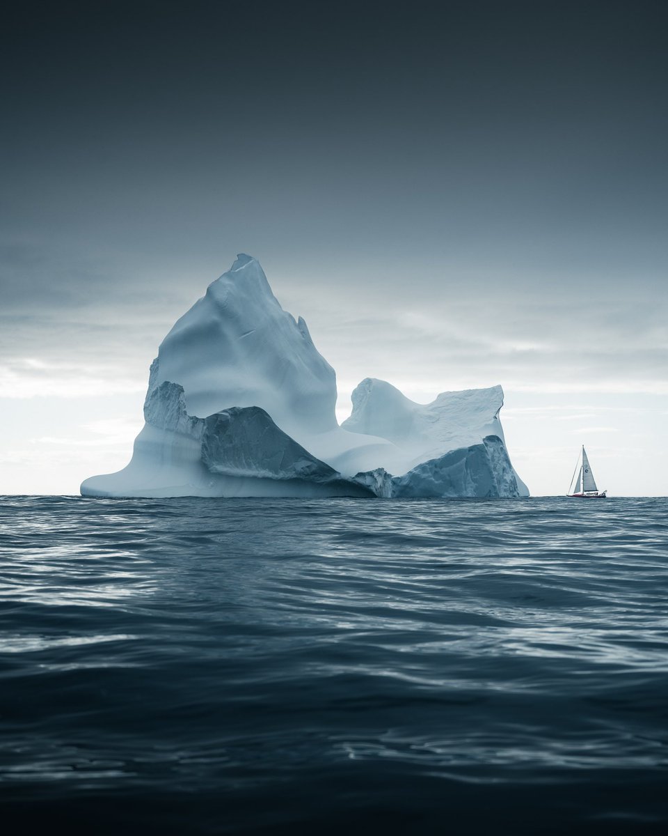 NorrisNiman's tweet photo. This is shot from our little dinghy so we could have our boat in there for scale. I later flew my drone over the tip of the icebergs and measured its height to 70m https://t.co/YFgypMOGgy