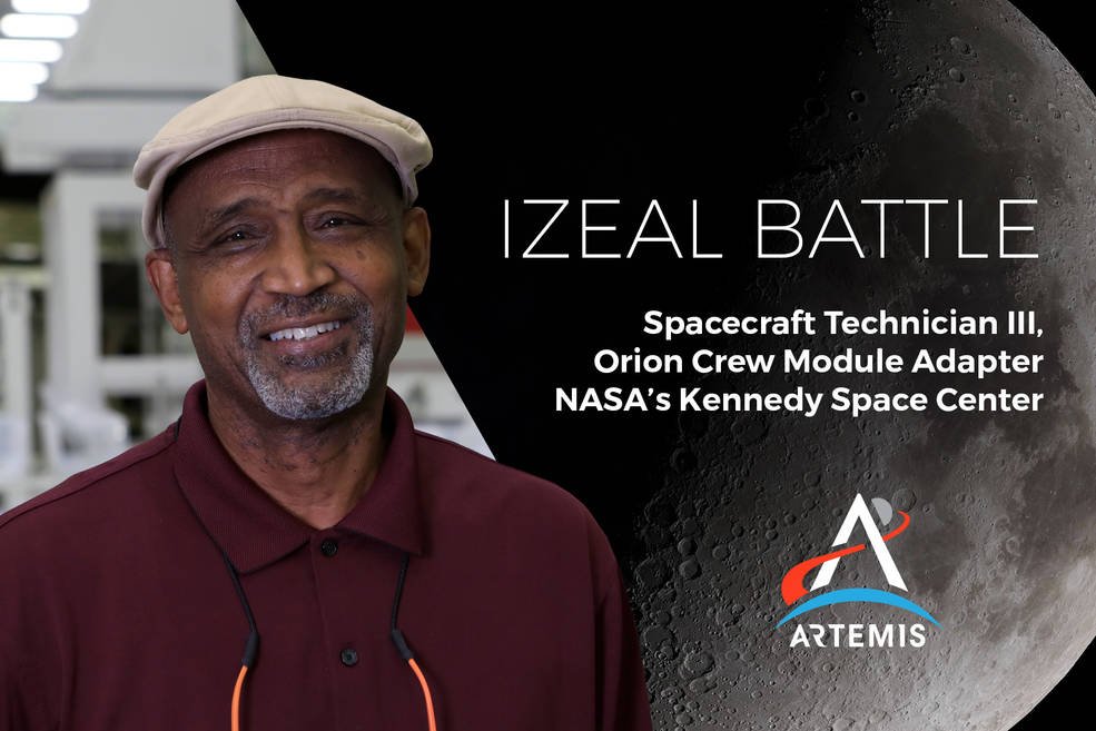 An African American man smiles wearing a maroon polo. The background is a picture of the Moon and the Artemis logo. 