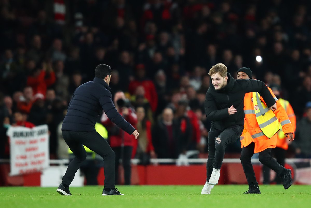 ChrisWheatley's tweet photo. Mikel Arteta attempting to stop a pitch invader during tonight's game. #ARSWHU https://t.co/oN2IzzhuSS