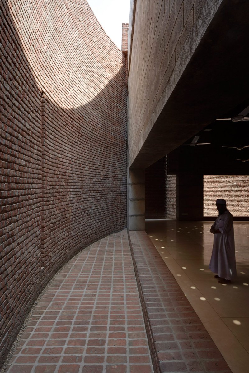masooma__ali's tweet photo. The award-winning Bait Ur Rouf Mosque in Dhaka, Bangladesh designed by Marina Tabassum. The terracotta brickwork allows sunlight and air into the open prayer hall. My favourite feature is the curved opening in the direction of the qibla, replacing a traditional mihrab. https://t.co/7WcDhIdNSf