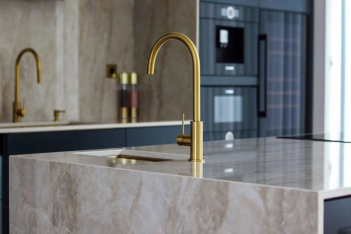 Dekton's tweet photo. This week's kitchen photos via @aomarmor put a golden edge on life, to say the least. A modern kitchen dressed with the popular and very impressive Dekton Arga as a worktop, which together with the gold-colored faucets and sinks become something special. https://t.co/wQz9JJ1pNs https://t.co/quJeqaoaHy