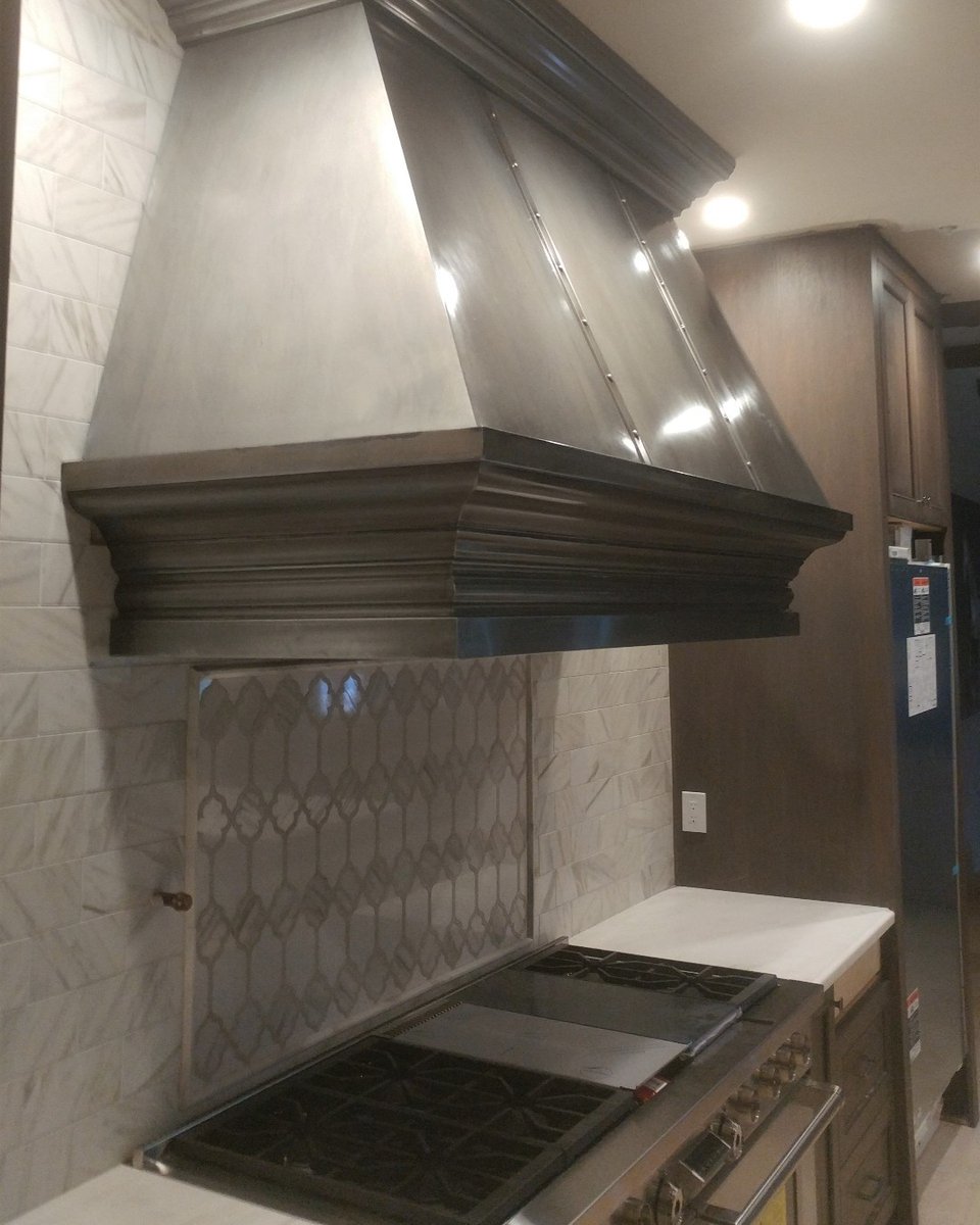 GrayleafStudio's tweet photo. Holiday cooking is a dream with this pewter range hood. Check out the edge profile and strap details, making this a true statement piece. https://t.co/mtZjFCDEvw