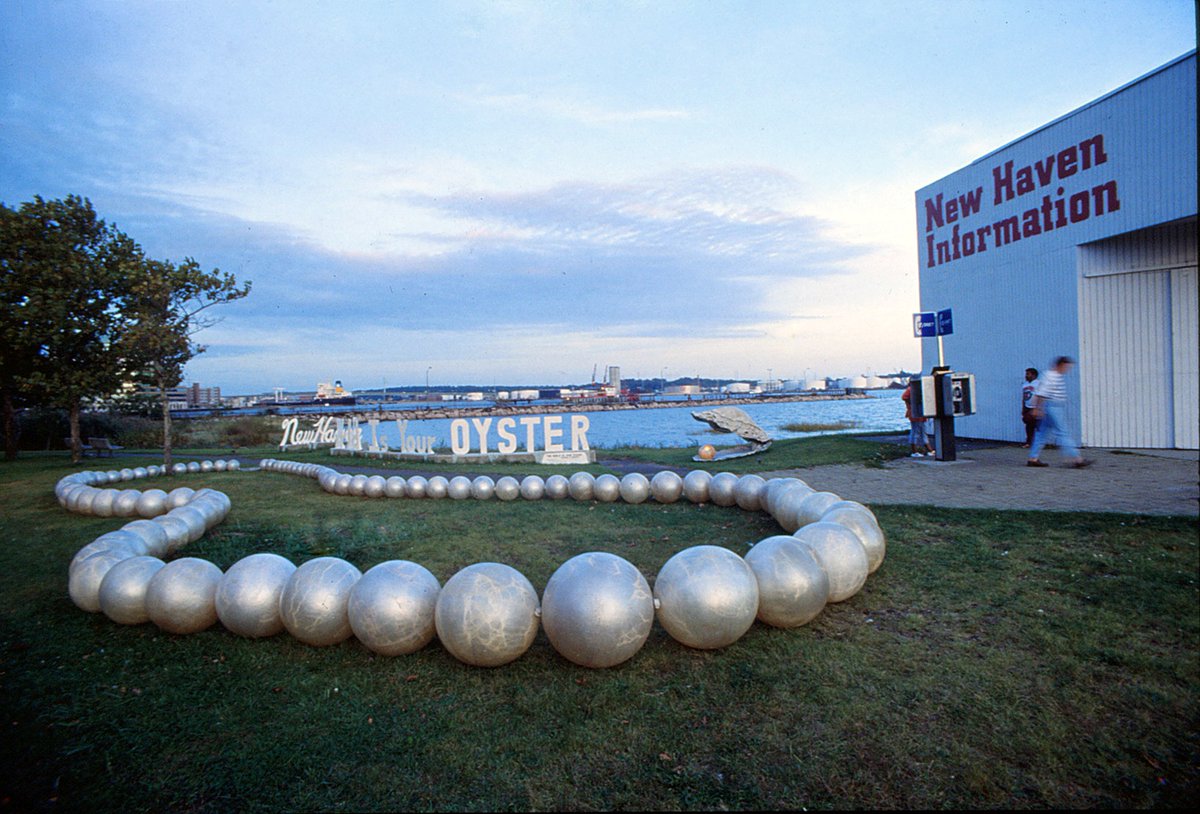 #theworldisyouroyster was installed in a park by the New Haven harbor along the roadside in 1990 and was composed of three-foot fiberglass pearls encircled in a tree and a seven foot-high oyster made from animation rubber powered by hydraulics opened-closed upon a "globe pearl".