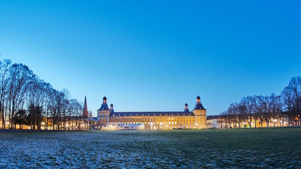 Das Hauptgebäude in der Dämmerung mit ein bisschen Schnee auf der Wiese. 