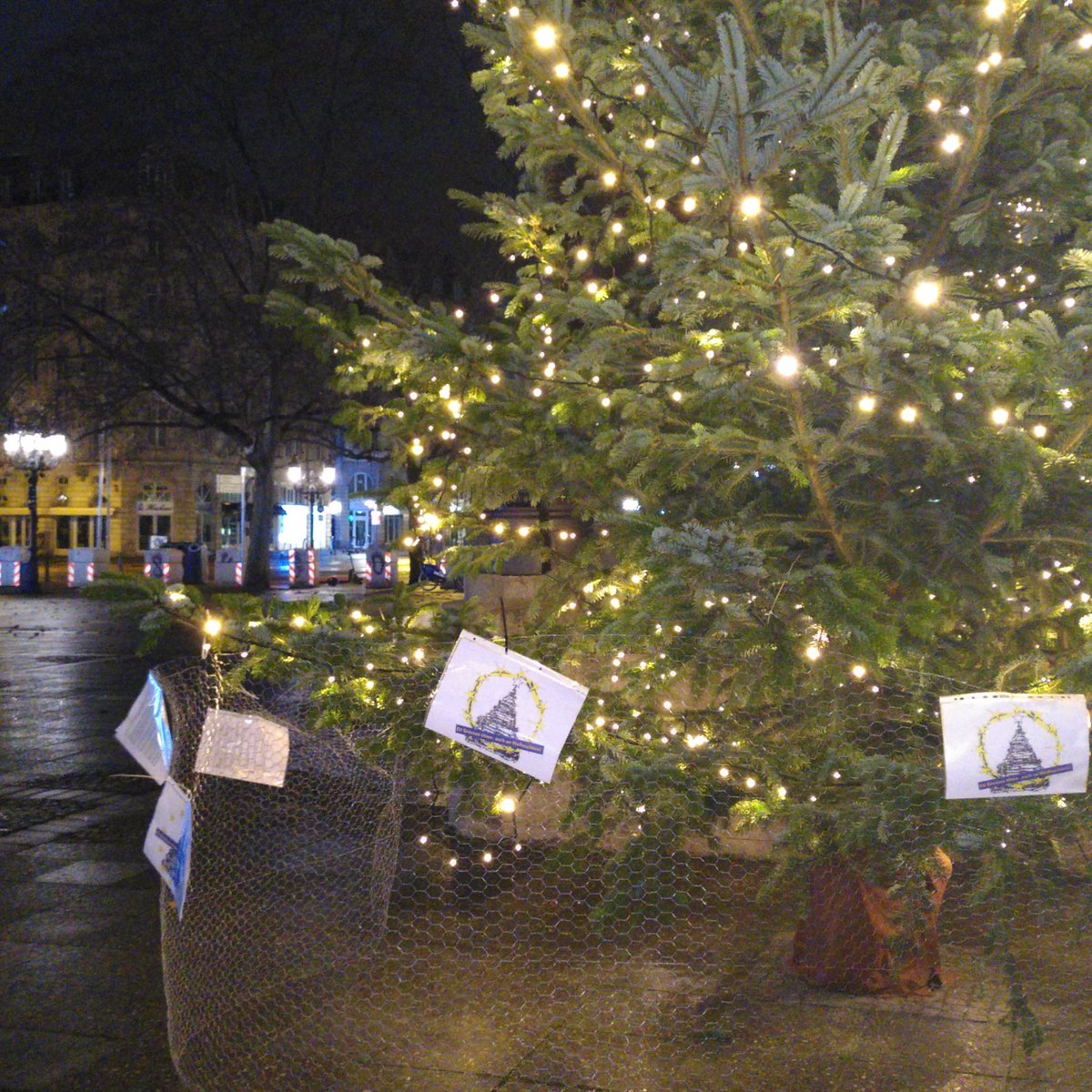 Ein eingezäunter Weihnachtsbaum an der alten Oper in Ffm. Mit Schildern: <a class=