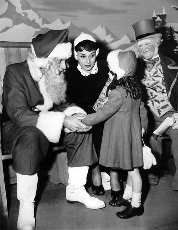 hepburndaily's tweet photo. audrey hepburn helping santa claus hand out gifts to children, 1952 🎁 https://t.co/82dklxz091