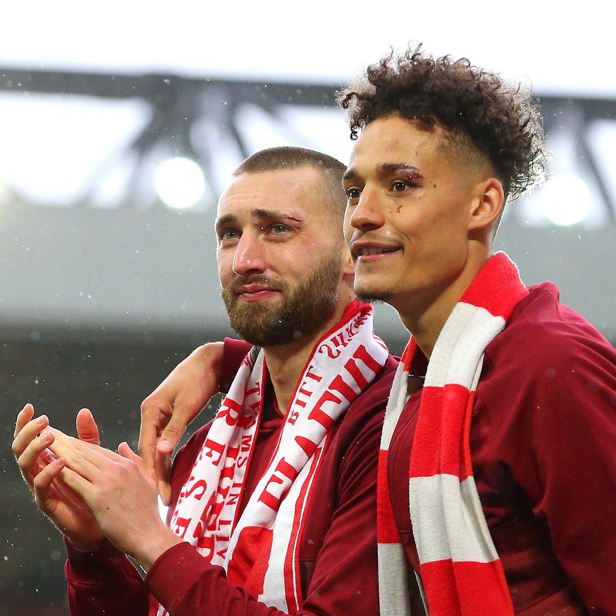 DaveOCKOP's tweet photo. Klopp: "There is a photo stuck in my mind of the final day of last season. It was taken after the game and we had 10,000 supporters back at Anfield. It shows Nat Phillips &amp; Rhys Williams applauding the fans in front of the Kop, both of them with bruises and cuts to their faces." https://t.co/0Ioc4VHZad