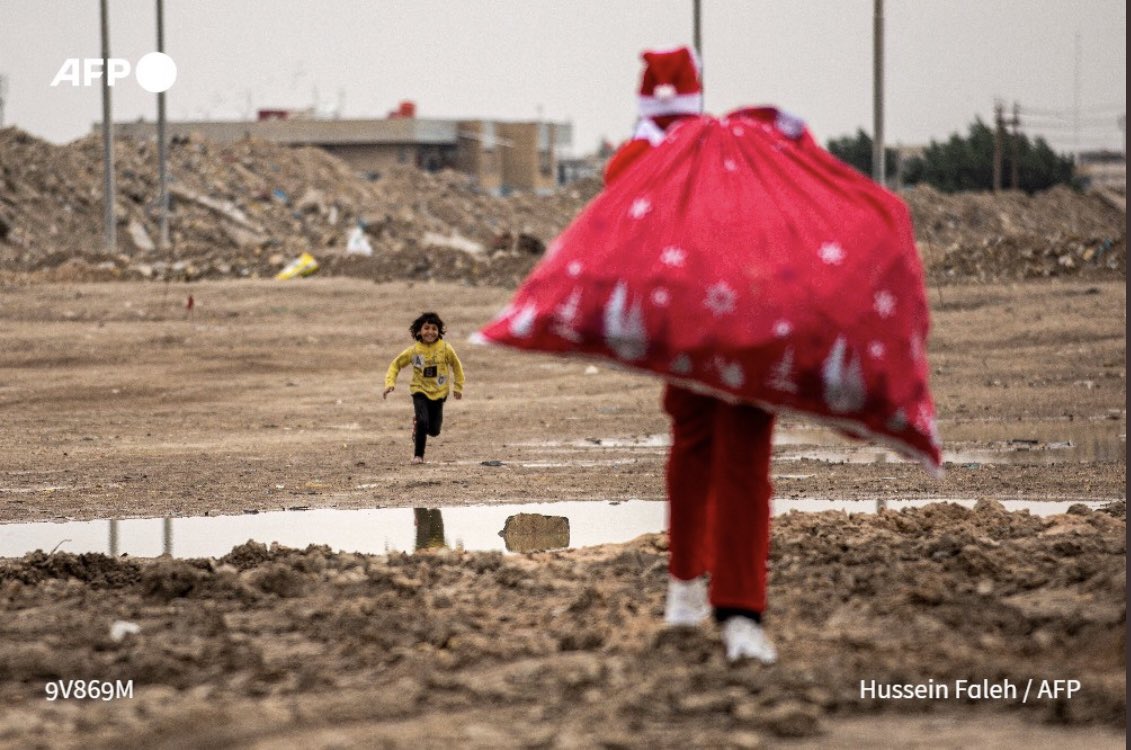 Cette photo qui m’a bouleversé ! Ce sourire clair dans les ruines 🇮🇶 Un enfant court vers Mohamed Maarouf, 28 ans, qui marche déguisé en Père Noël, un sac rempli de cadeaux sur l'épaule, dans un bidonville près du centre de la ville de Bassorah, dans le sud de l'Irak #AFP