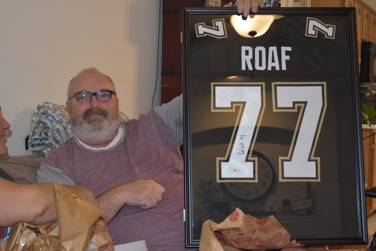 49erintx's tweet photo. It pains me to buy non-49er gear, but the excitement displayed by my father in law when he opened the autographed @Willie_Roaf jersey I got him made it all worth it! The look on his face when my mother in law says “Who’s Willie Roaf?!”was priceless! #FTTB #SAINTS #AFamilyDivided https://t.co/a6IuK6i4XM