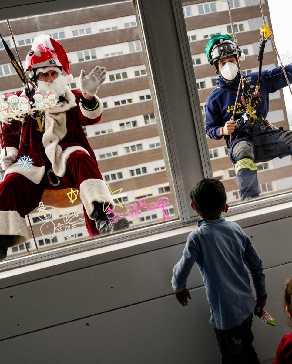 Papá Noel y los Bombers Solidaris visitan colgados del techo del Hospital Trias i Pujol de Badalona a los niños ingresados y a los sanitarios.

📸 Enric Fontcuberta (Efe)