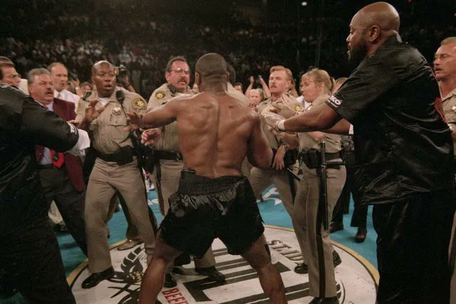 Youridefou's tweet image. La police de Las Vegas face à Mike Tyson juste après qu'il ait mordu l'oreille de Holyfield, son adversaire ce soir là (1996). La photo me fume😭