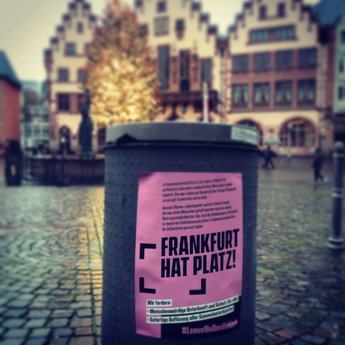 Ein Frankfurt hat Platz - Plakat an einer Mülltonne vorm Römer. Dort leuchtet der Frankfurter Weihnachtsbaum.