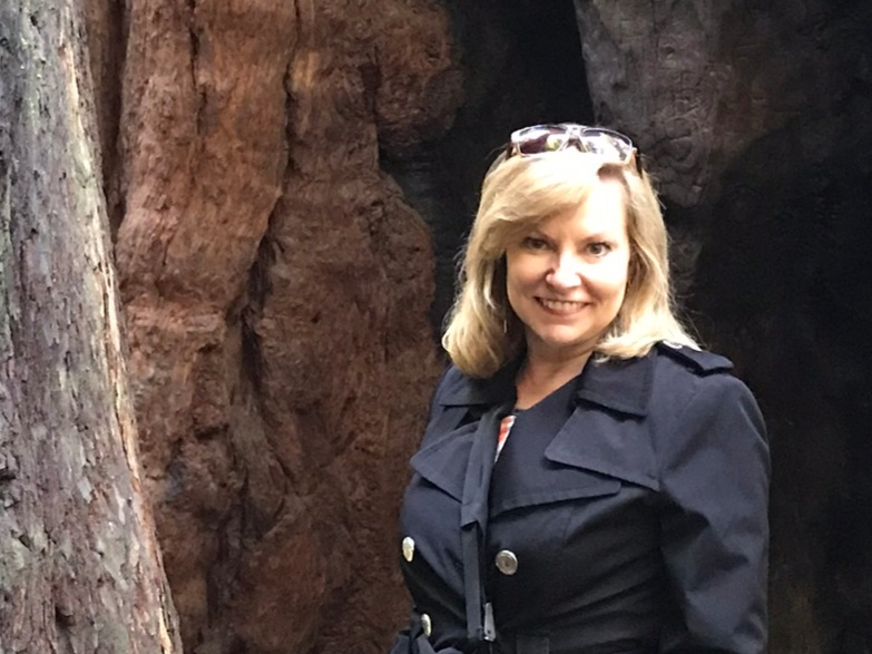 Victoria Stowe outdoors in a forest carrying a camera