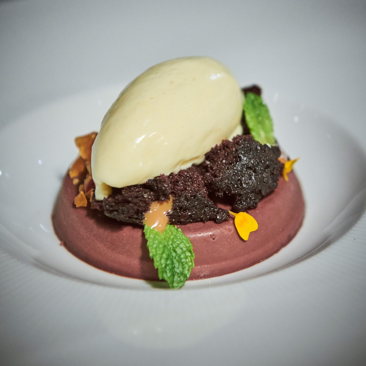 Fluffy chocolate cake crumbles, smooth passionfruit ice cream, and a crunchy cashew croquant – what more could you ask for? Complete your meal with this delicious @comperelapin dessert! 📸: Chocolate Ganache #GourmetFood #Cuisine #FineDining
