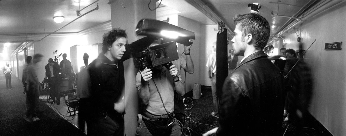 AmericanCine's tweet photo. #ACArchive: In this photo by unit photographer Peter Sorel, DoP Darius Khondji, ASC, AFC adds bit of light to a handheld shot on actor Brad Pitt while filming the stylish serial killer drama Seven (1995), directed by David Fincher. https://t.co/GsybH8U91e