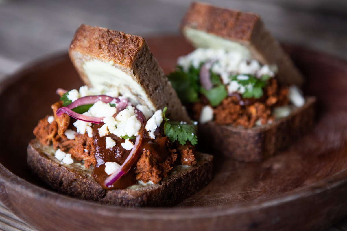 jesterkingbeer's tweet photo. Try our Turkey Mole Sloppy Joe this week! 🥪 Comes with smoked turkey, peanut mole, house herbed sourdough, cilantro, red onion, cotija, jalapeño aioli, and lime juice. Contains peanuts. Available onsite & to go at the link: https://t.co/7S2TqwPBsh #JesterKingKitchen #AustinTexas https://t.co/SImSkWsjcy