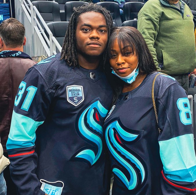 image of deejay dallas posing for a photo at climate pledge arena in a blue kraken home jersey