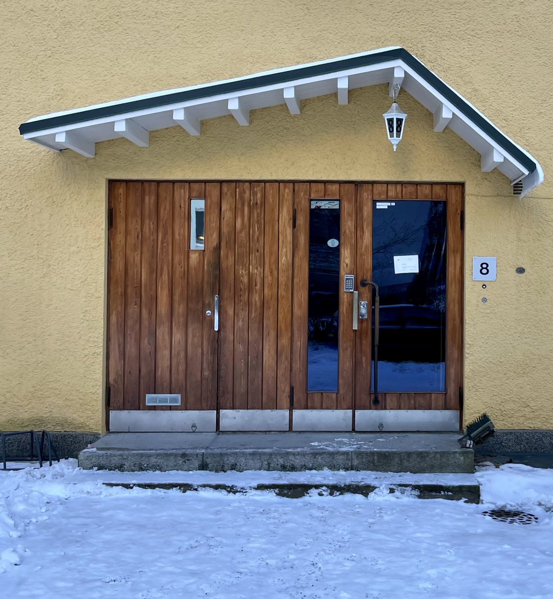 lasersilma's tweet photo. Spotted during a brisk, wintry walk. I like the asymmetrical overhang, the cute lantern with the building number and the little window in the leftmost door. #doorwaysofhelsinki https://t.co/dtl83qL2JZ
