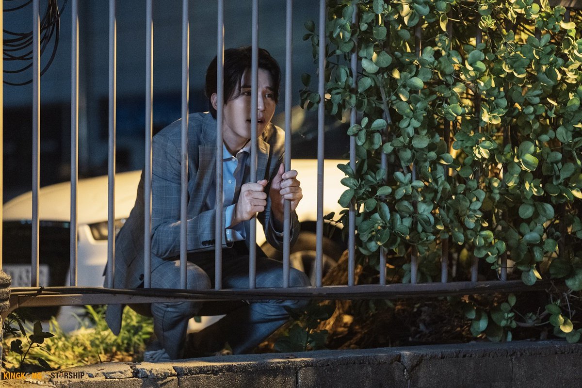 lee dongwook crouching down looking tiny and distressed holding gates for dear life