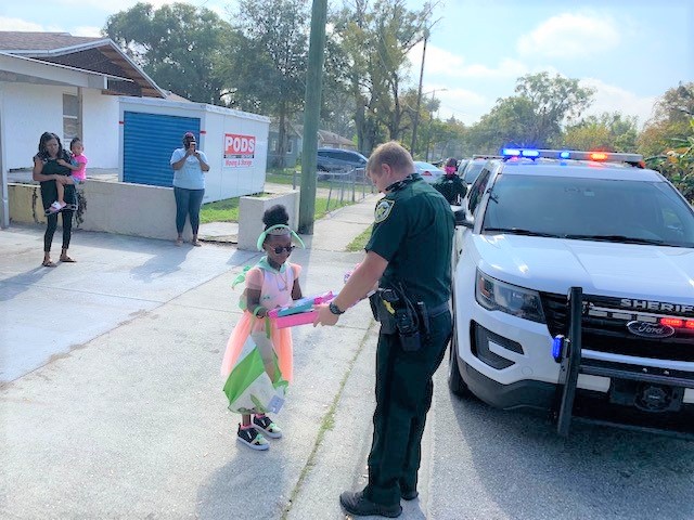OrangeCoSheriff's tweet photo. When a mom asked for a visit for her daughter's 6th birthday, our deputies jumped at the chance to make the little girl feel special. They drove to the home w/ their lights on &amp; brought gifts! The birthday girl gave them goody bags to thank them. What a perfect way to end 2021!✨ https://t.co/fLfZLjmaQR