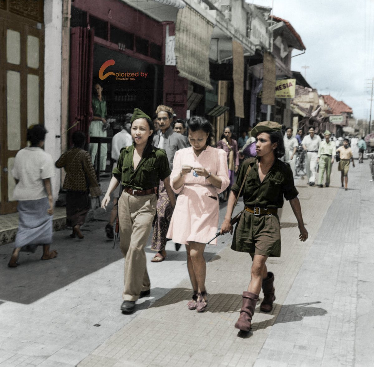 Dua perempuan tentara sukarelawan KRIS (Kebaktian Rakyat Indonesia Sulawesi) sedang berjalan di pusat kota Yogyakarta bersama seorang teman mereka (tengah), Desember 1947.