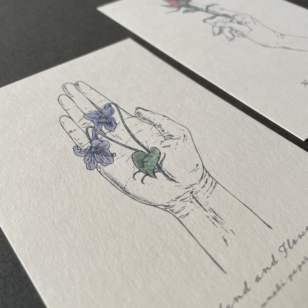 #手と花

カードは「菫の花」「薔薇の蕾」の2種類。
カードのみの販売はございません。
どちらも花を持っているように見えて、手から生えている…というコンセプトで描きました。
不思議なイラストを小さくて愛らしいスワッグと共に楽しんでいただきたいです。 