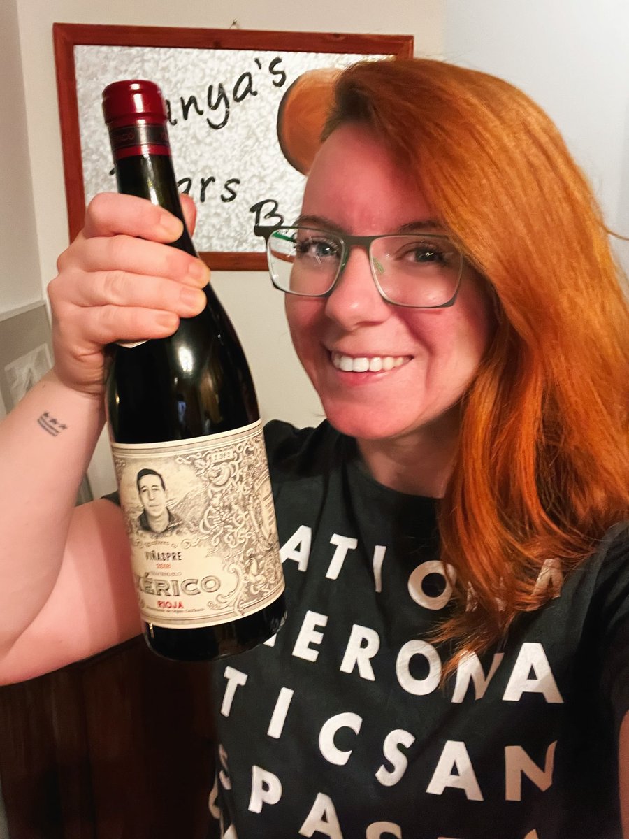 Tanya holding a celebratory bottle of wine wearing a NASA shirt by @thespacegal Emily Calandrelli